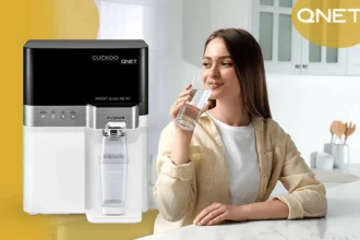 A young lady drinking water from Cuckoo water purifier