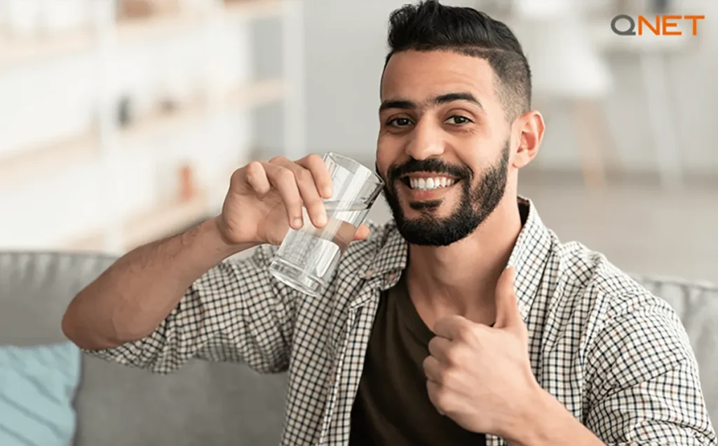 A young man drinking water in the morning